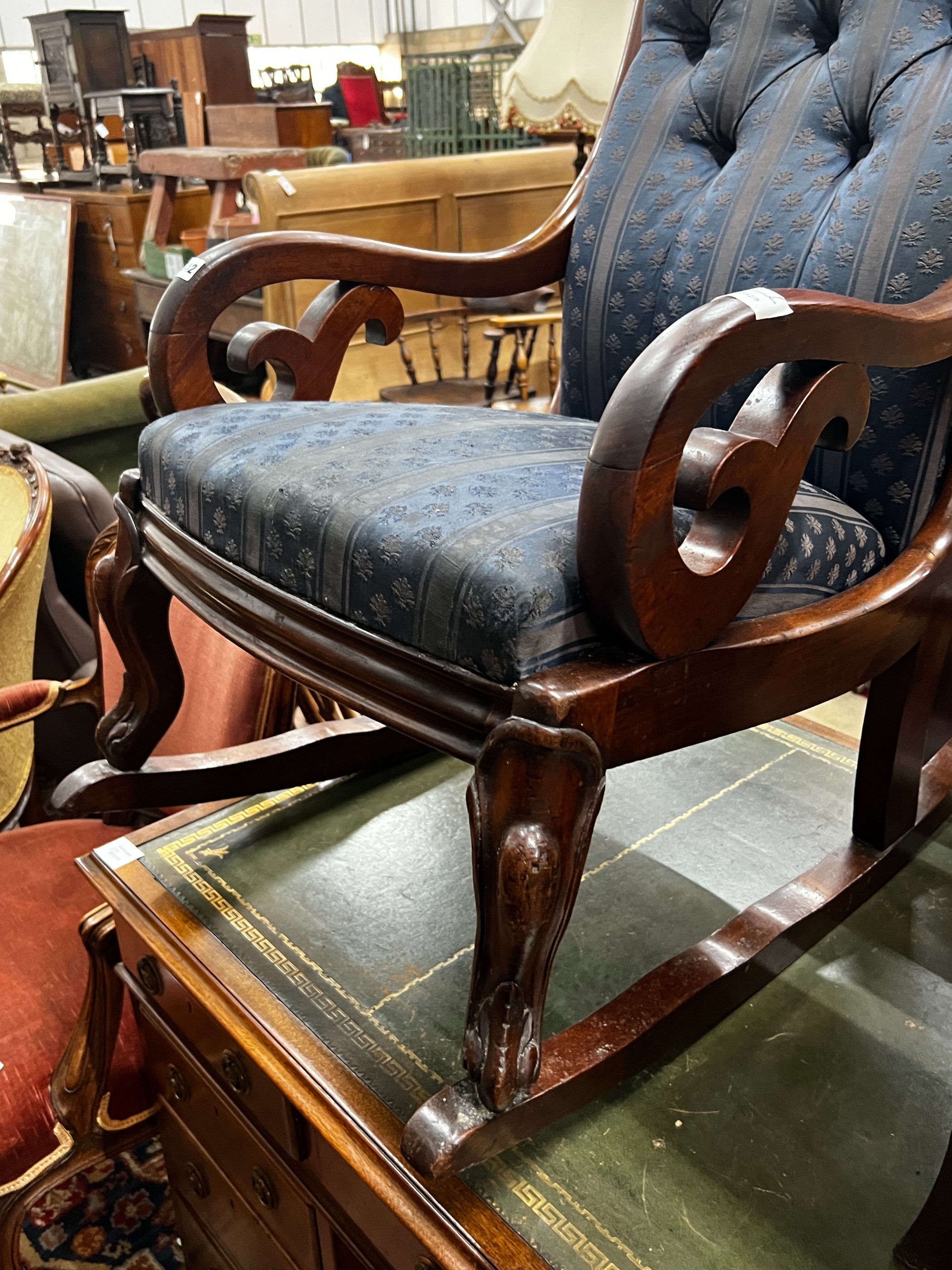 A Victorian carved mahogany upholstered rocking elbow chair, width 53cm, depth 76cm, height 104cm